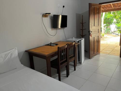 een kamer met een tafel, een bed en een televisie bij POUSADA PARAÍSO CULTURAL in Barreirinhas