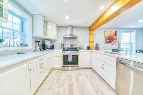 a kitchen with white cabinets and a stove top oven at New 3b House in Saugerties Village 4 mins to HITs in Saugerties