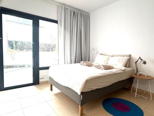 a bedroom with a bed and a large window at Casa Mirador del Castillo in Cotillo
