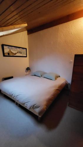 une chambre avec un grand lit blanc dans une pièce dans l'établissement Duplex au centre de la station, à Arâches-la-Frasse