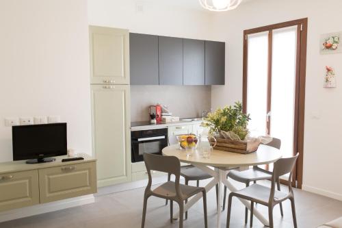 a kitchen with a table with chairs and a tv at Queen Venice Fly Apartments in Campalto
