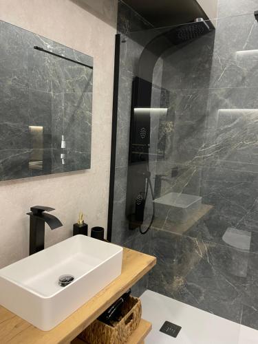 ein Badezimmer mit Waschbecken und Dusche in der Unterkunft Plaza Mayor de Salamanca Apartamentos para grupos in Salamanca