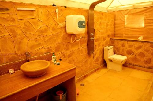 ein Badezimmer mit einem hölzernen Waschbecken und einem WC in der Unterkunft Desert Safari Dubai Over Night Stay in Hunaywah