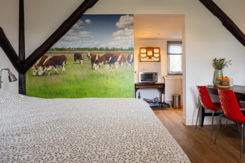 a bedroom with a large painting of cows in a field at Studio Hooischuur Alkmaar/Bergen in Alkmaar