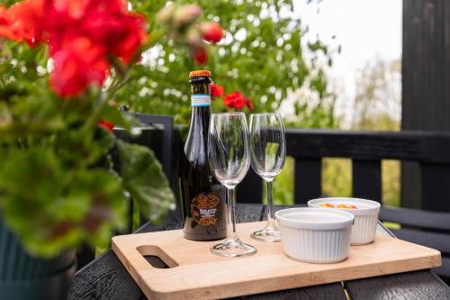 a bottle of wine and two glasses on a wooden tray at Studio Hooischuur Alkmaar/Bergen in Alkmaar