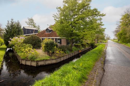 a house on the side of a canal at Studio Hooischuur Alkmaar/Bergen in Alkmaar