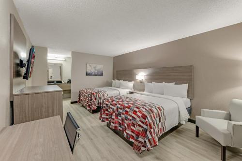 ein Hotelzimmer mit 2 Betten und einem TV in der Unterkunft Red Roof Inn Kingsport in Kingsport