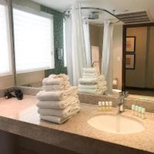 a bathroom with a sink and a pile of towels at Congress Ocean Drive in Miami Beach