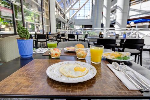 a table with two plates of food and drinks on it at Radisson São Paulo Paulista in Sao Paulo