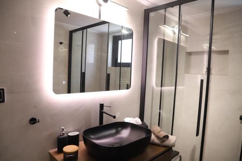a bathroom with a black sink and a mirror at Villa Achilleas by the sea in Anavissos