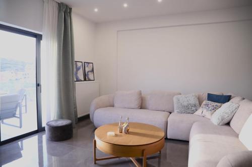 a living room with a couch and a table at Villa Achilleas by the sea in Anavissos