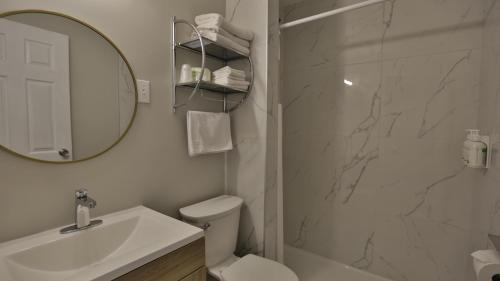 a bathroom with a sink toilet and a mirror at Diplomat Motel in Nanaimo