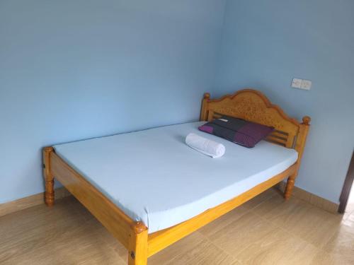 a bed in a room with a blue wall at Moorthy House in Kankesanturai
