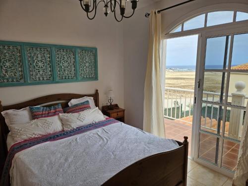 a bedroom with a bed with a view of the ocean at Casa Golden in Caleta De Fuste