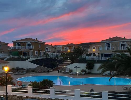 a sunset over a swimming pool at a resort at Casa Golden in Caleta De Fuste