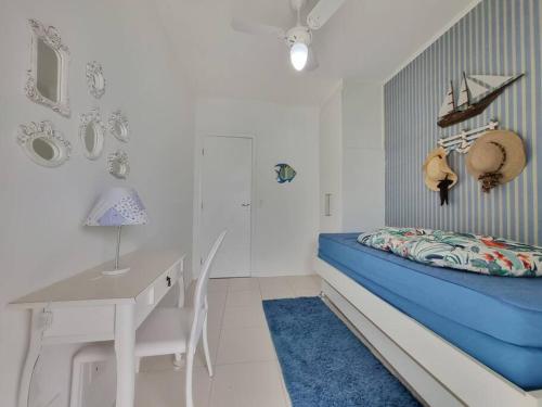 ein Schlafzimmer mit einem Bett, einem Schreibtisch und einem Tisch in der Unterkunft Plaza Riviera - Módulo 6 - 2 Quartos - 300 metros da praia in Riviera de São Lourenço