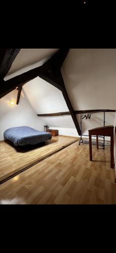 Cette chambre mansardée dispose d'un lit et de parquet. dans l'établissement Maison de ville avec terrasse, à Bourges