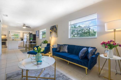 a living room with a blue couch and a table at Sparkling Oasis near Downtown ST Pete/Beach in St. Petersburg