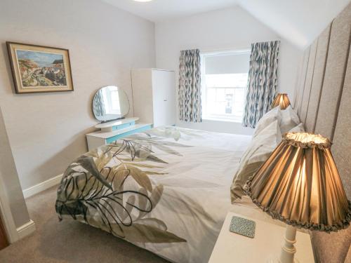 a bedroom with a bed and a lamp and a television at May Cottage in Scarborough