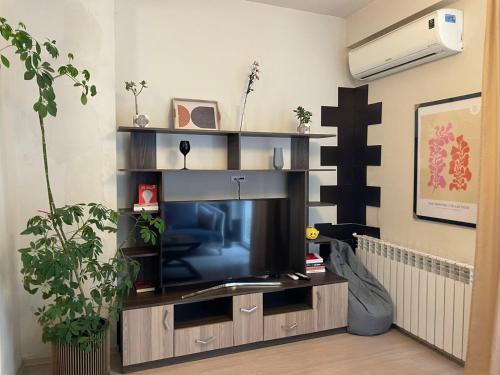 sala de estar con TV en un centro de entretenimiento en Chavchavdze VAKE - 1BR Apartment, en Tiflis