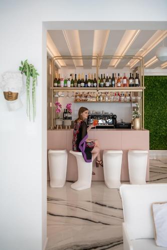 a woman sitting on a toilet in a bar at Lagon Life Spirit Boutique Hotel - Adults Only in Chania Town