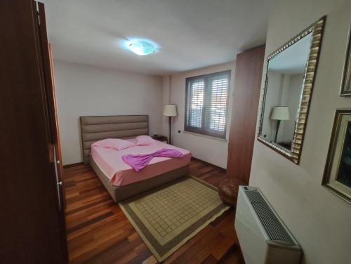 a small bedroom with a bed and a mirror at A Flower in Tirana in Tirana