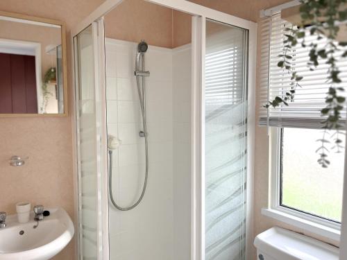 a bathroom with a shower and a sink at Serenity Lodge, Riverside with Free Parking in Christchurch