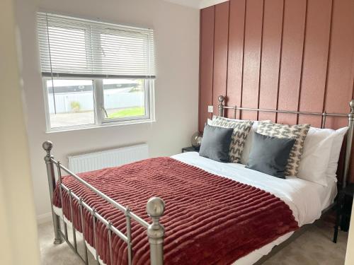 1 dormitorio con 1 cama con cabecero rojo en Serenity Lodge, Riverside with Free Parking en Christchurch