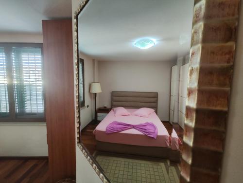 a small bedroom with a bed with purple sheets at A Flower in Tirana in Tirana
