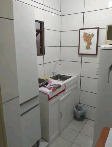 阿雷格里港的住宿－Apartamento Confortável，白色的小厨房,配有水槽和镜子