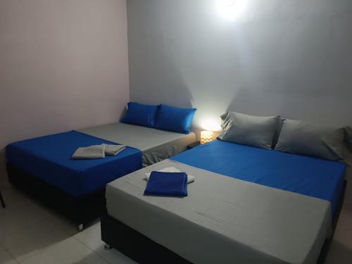 2 camas en una habitación con azul y gris en Tamarindo en Santa Marta