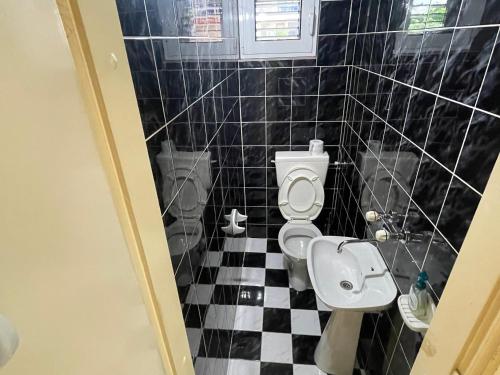 a bathroom with a black and white checkered floor at Apartments Moreno in Budva