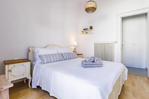 a bedroom with a large white bed with towels on it at Iria's Petite Apartment in Skopelos Town