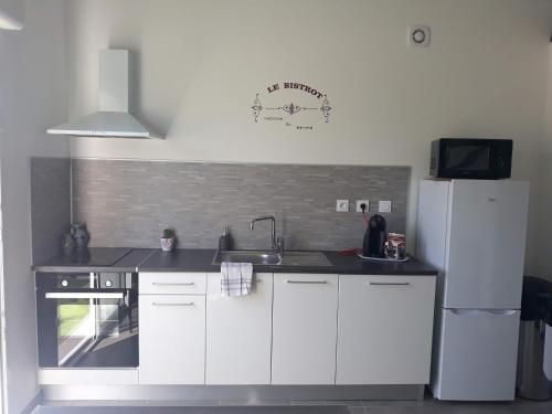 une cuisine avec un évier et un réfrigérateur dans l'établissement coquillage, à Saint-Mitre-les-Remparts