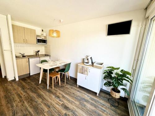 une petite cuisine avec une table, des chaises et une table dans l'établissement Résidence Le Boucanier - Studio pour 4 Personnes 421, à Vieux-Boucau-les-Bains