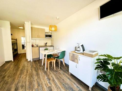 une cuisine avec une table et des chaises dans une pièce dans l'établissement Résidence Le Boucanier - Studio pour 4 Personnes 421, à Vieux-Boucau-les-Bains