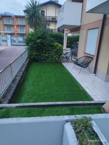 a yard with a lawn in front of a building at Magic Riva Apartment in Riva del Garda