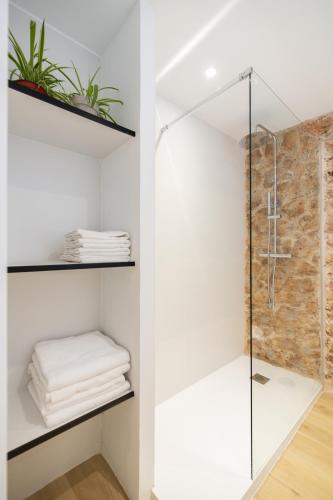 a bathroom with a glass shower stall with towels at Casa con historia en el centro. in Castellón de la Plana