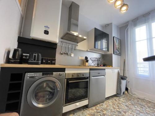 une cuisine avec une machine à laver et un lave-linge dans l'établissement Le Treize au cœur du bouchon, à Troyes