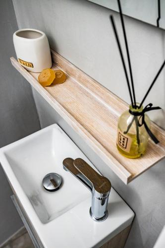 a bathroom sink with a counter and a vase on a shelf at Iria's Petite Apartment in Skopelos Town