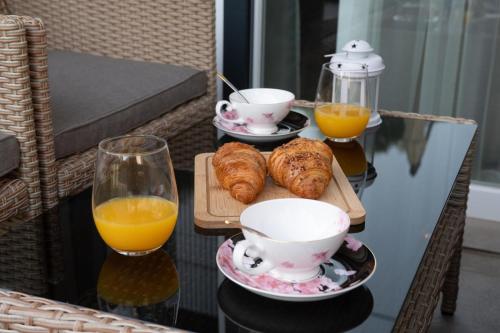 a table with two cups of orange juice and croissants at Studio Apartman Apollonia in Sinj