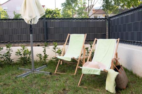 two lawn chairs and an umbrella in a yard at Studio Apartman Apollonia in Sinj