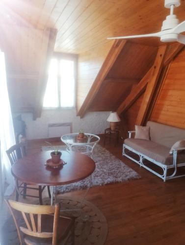 un salon avec une table et un canapé dans l'établissement Ambiance chalet Salles-Curan, à Salles-Curan