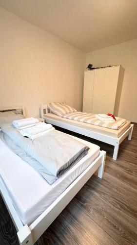 - 2 lits dans une chambre dotée de parquet dans l'établissement Charmant hell citynah, à Wiesbaden