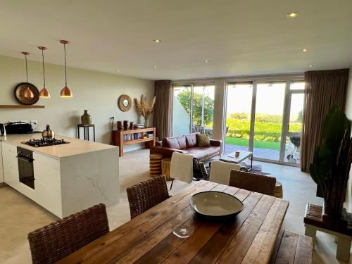 a kitchen and living room with a wooden table and chairs at Dolphin Beach Cabana in Table View