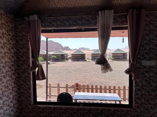 a view of a bedroom window with a view of a yard at Dream Bedouin life camp in Wadi Rum