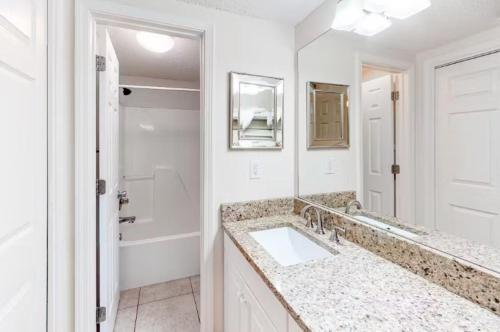 a white bathroom with a sink and a mirror at Caribbean Unit 602 in Gulf Shores