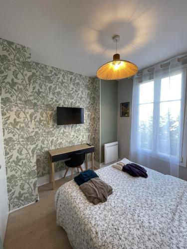 une chambre avec un lit, un bureau et une télévision dans l'établissement Le Treize au cœur du bouchon, à Troyes