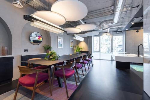 a dining room with a long table and pink chairs at Woodward Square One by Dublin At Home in Dublin
