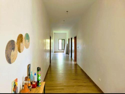 a hallway with white walls and a wooden floor at Keur Aïda in Malikounda Sas